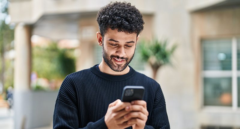 Unleash the Power of Your Digital Comms with Our New Zapier Integration_Everlytic Blog_Person Reading off a Cell Phone